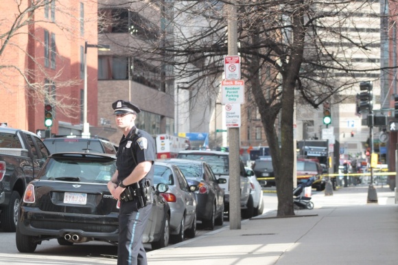 A Boston Police officer maintaining a security perimeter around the blast site.